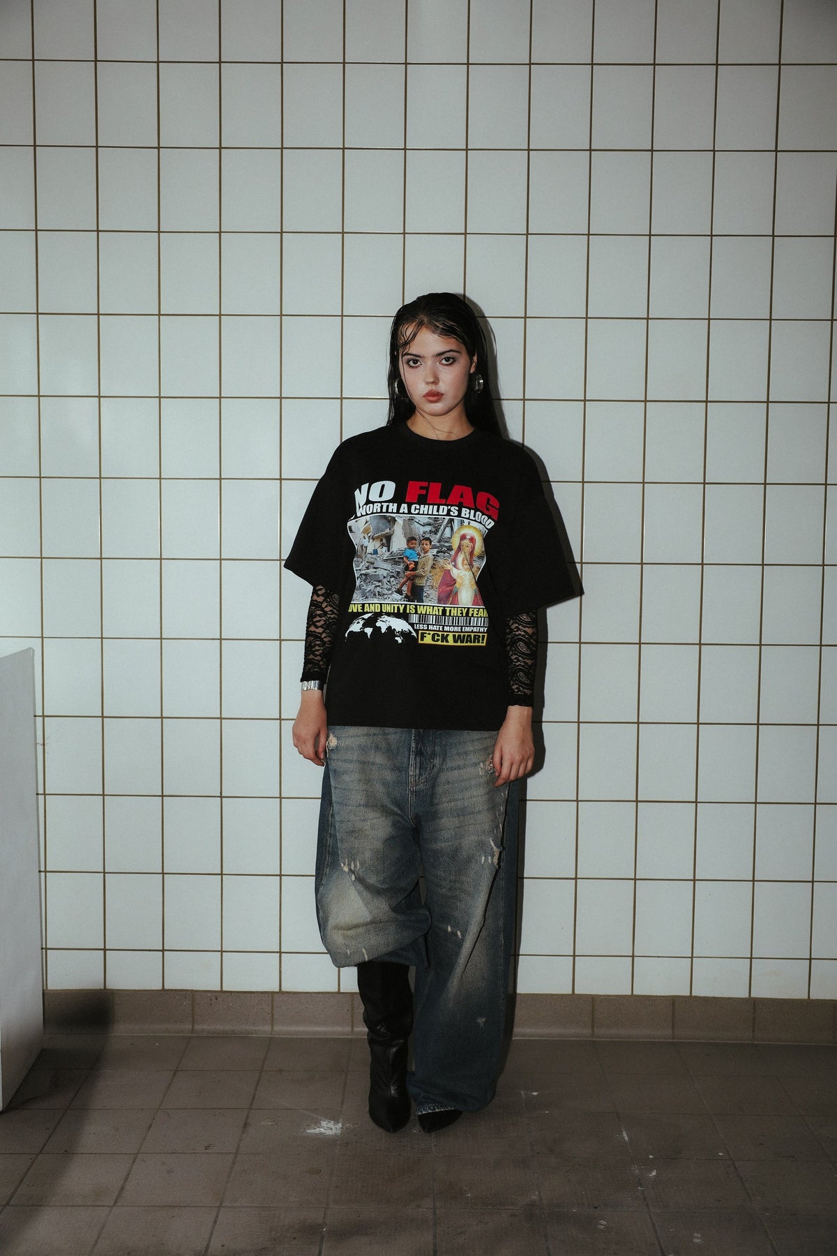 NO FLAG black graphic T-shirt, full-length front view on a model against a tiled wall.