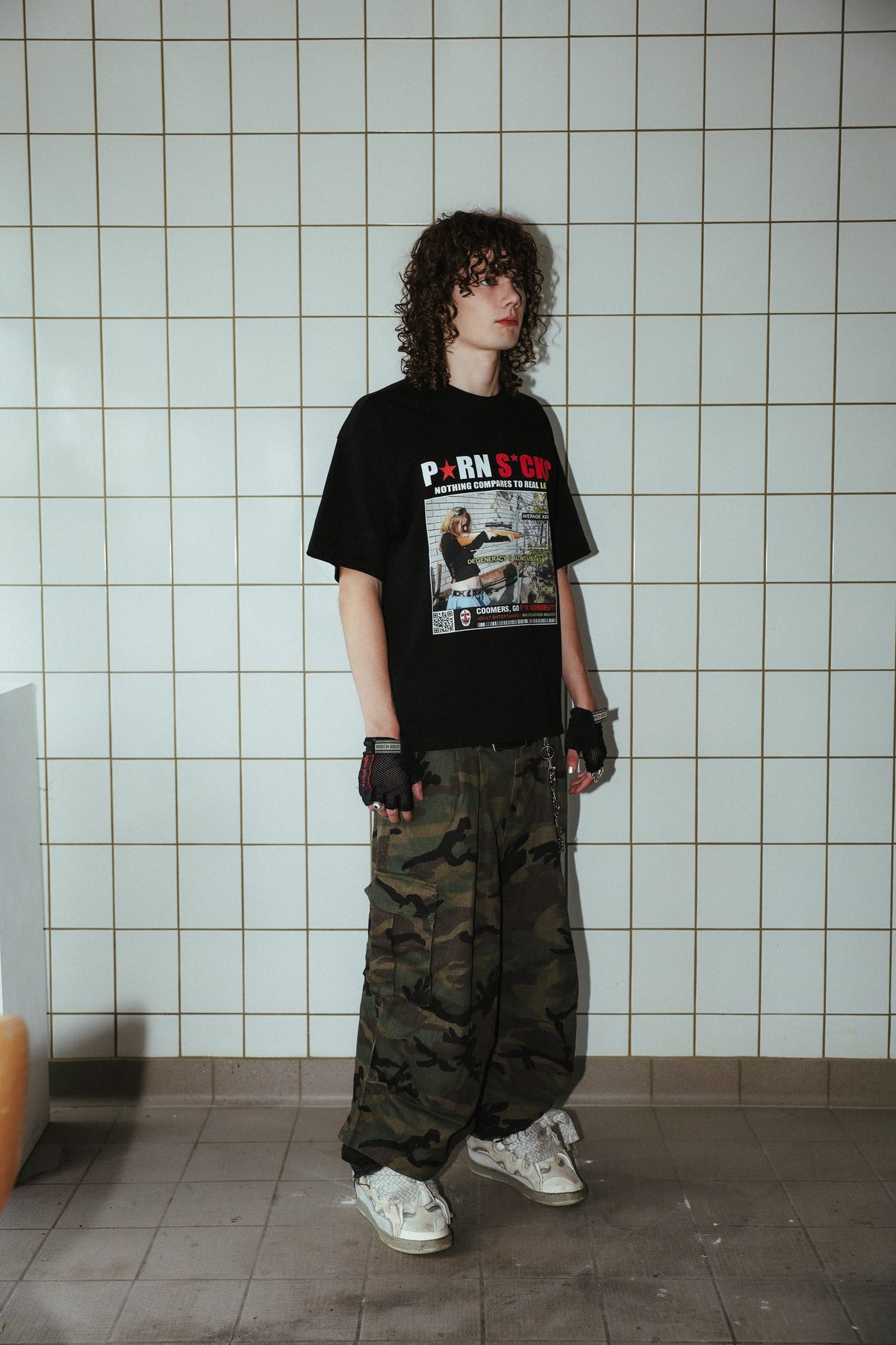 P★RN S*CKS black graphic T-shirt, side view on a model showing the sleeve and loose fit.