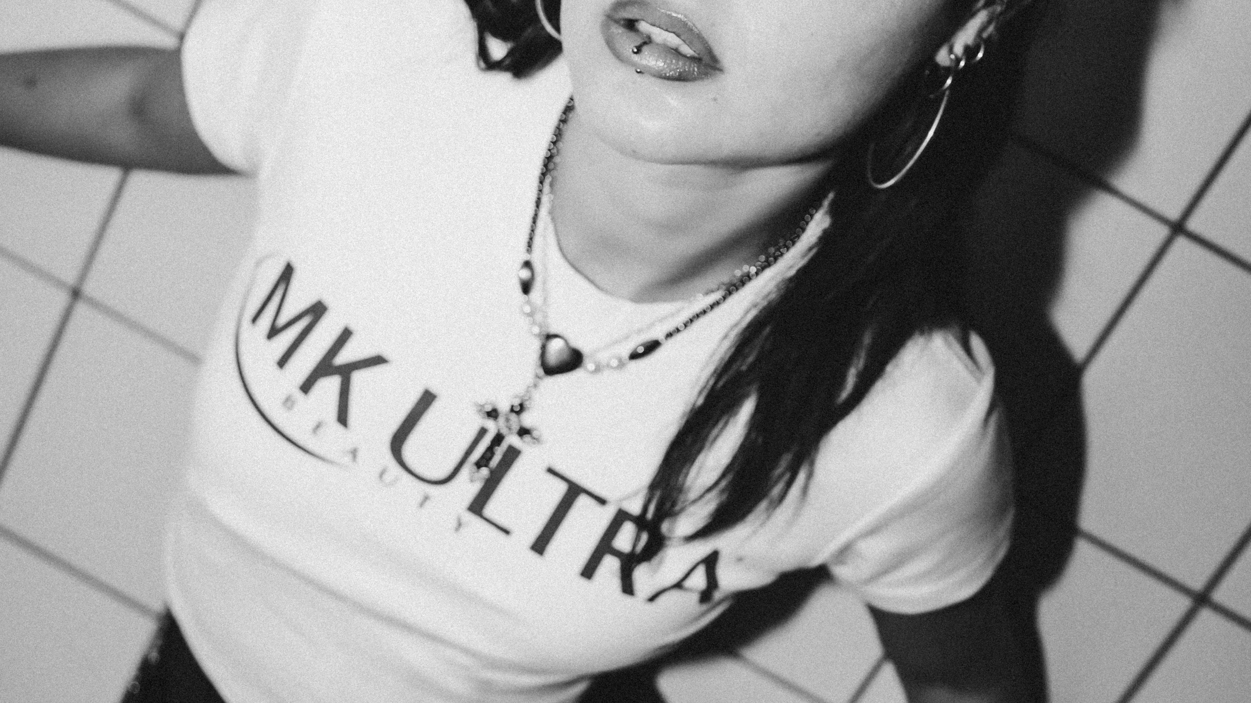 Black-and-white close-up of a model wearing the MK Ultra Beauty crop top